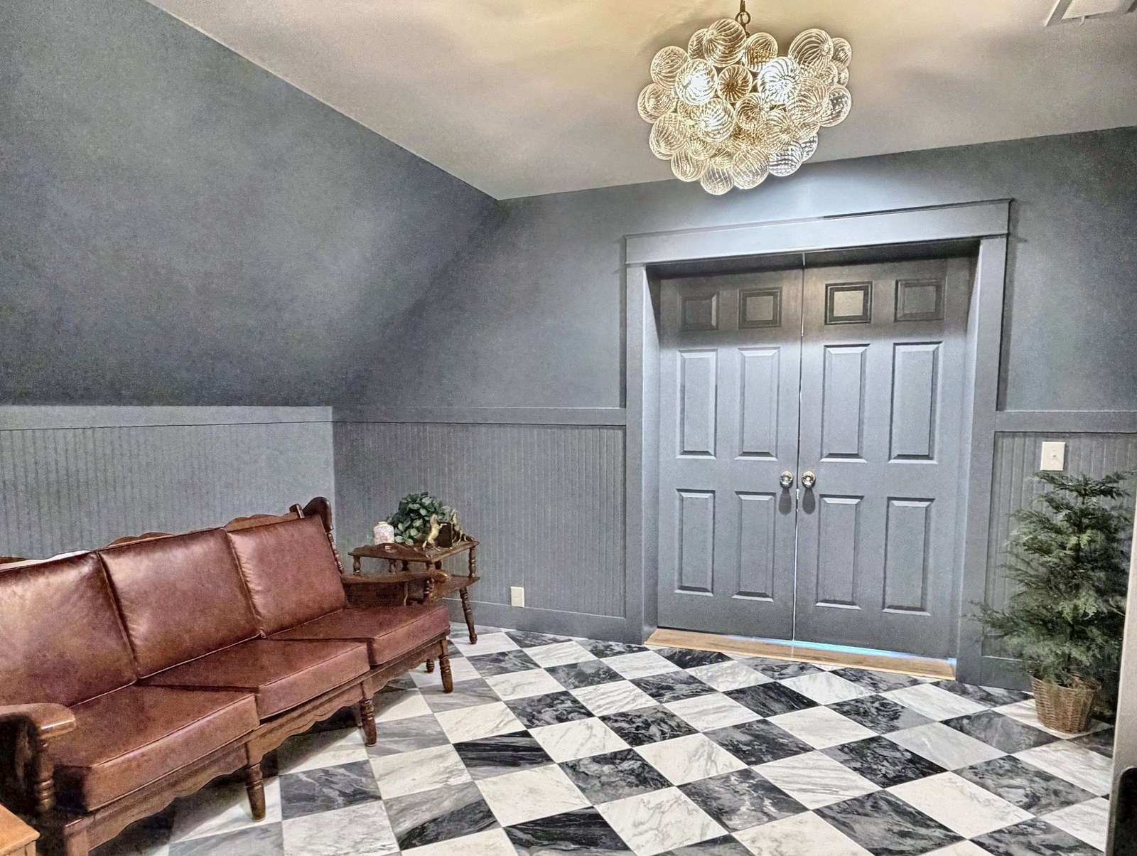 Blue-grey room with leather sofa and checkered marble floor